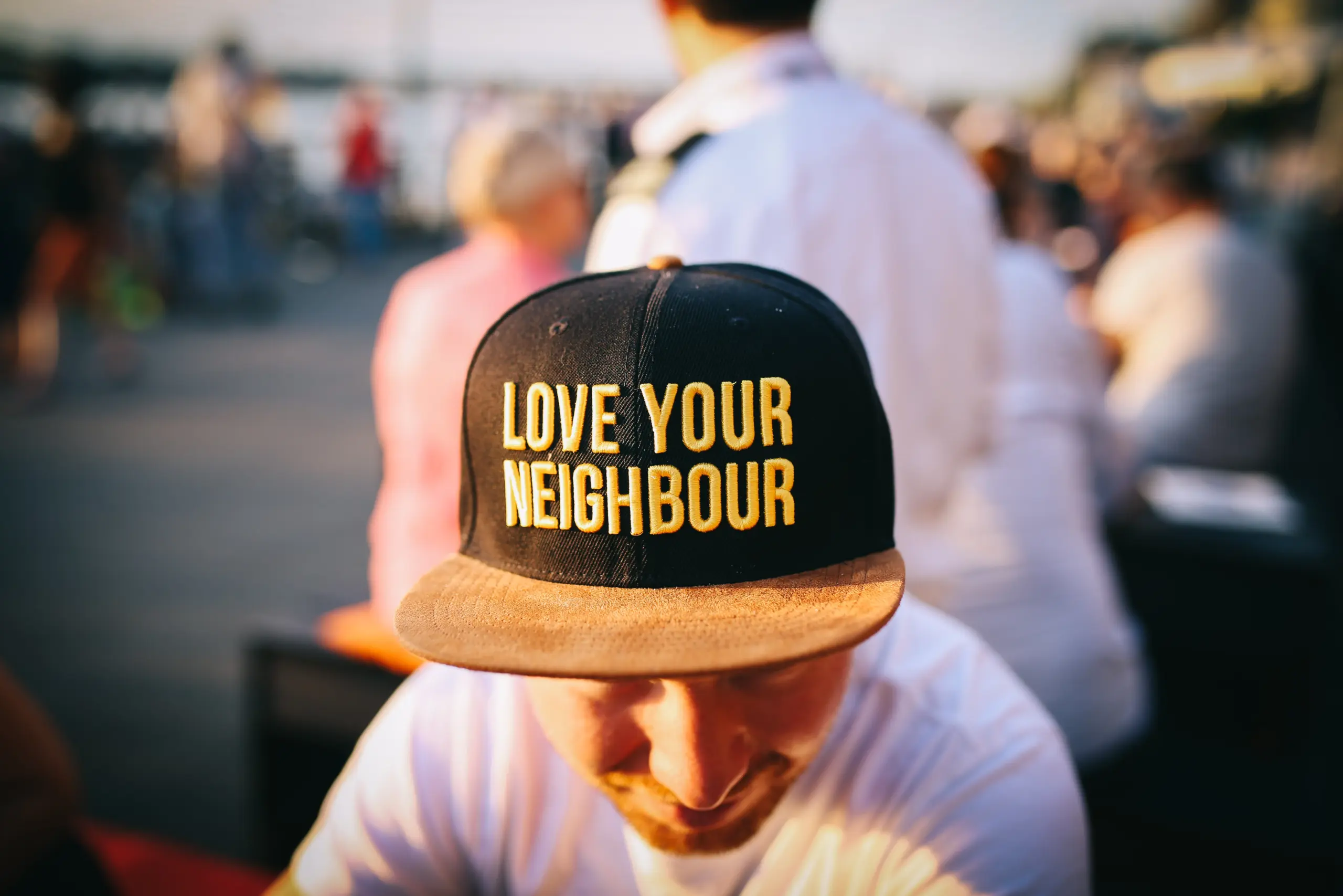 Man wearing a hat that says, love your neighbour